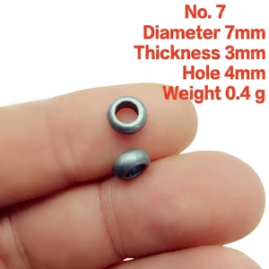 Macro shot of 7mm metallic spacer bead on fingertip showing precise dimensions and hole