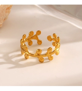 Macro shot of gold leaf branch open ring on minimalist stone base for women