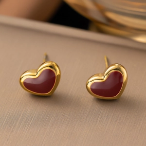 Makroaufnahme eleganter roter Herz-Ohrstecker mit luxuriösem goldenem Metallrahmen