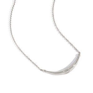 Macro detail of a silver polished curved bar pendant on a delicate link chain necklace