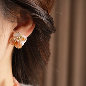 Close-up of vintage floral earrings with pink gradient petals and pearl accents