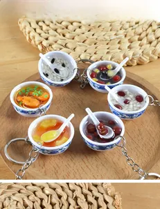 Macro view of six mini blue and white porcelain bowl food models with metal keychains