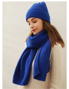 Detailaufnahme des blauen Stricksets aus Schal und Mütze am Modell bei natürlichem Licht