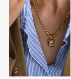 Macro view of gold pendant featuring a crystal heart inlay on a snake chain necklace