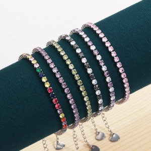 Close-up of assorted colorful zircon tennis bracelets with heart pendants on display