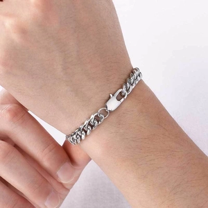 Gros plan d'un bracelet gourmette en acier inoxydable poli porté au poignet avec fermoir