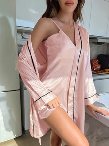 Détail de l'ensemble peignoir en satin rose avec bordure noire et texture soyeuse col en V