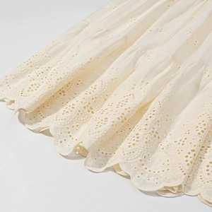 Detail of white Broderie Anglaise lace skirt hem with embroidered floral patterns