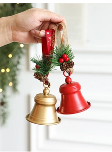 Detail of red and gold Christmas bells with pine needles, berries, and pinecones decor