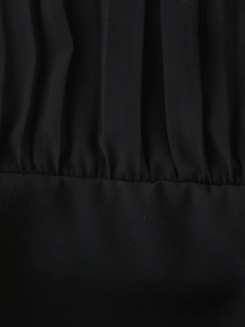 Detailed macro view of black pleated chiffon fabric and precise stitching on the dress