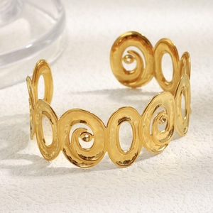 Vue rapprochée du bracelet torsadé ajouré plaqué or 18 carats sur surface texturée