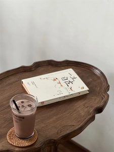 Scenographic view of a dark wood tray with wave-shaped edges for vintage home decor
