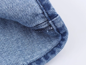 Detailansicht der blauen Denim-Stofftextur und der verstärkten Doppelnaht an den Säumen
