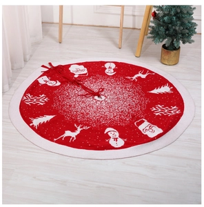 Detail of red Christmas tree skirt with white festive patterns on wooden floor