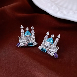 Macro view of 18K gold plated castle earrings with colorful zircon gems on red velvet
