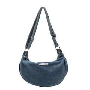 Blue denim crescent crossbody bag with adjustable strap and fashion label detail