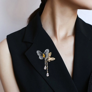 Broche papillon de luxe française avec glands dorés et zircons sur une veste de costume noire