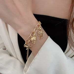 Detailed view of ocean-themed gold chain bracelet with starfish and octopus charms