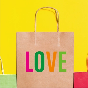 Close-up of kraft paper gift bag with large colorful LOVE letters and fiber texture
