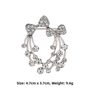 Détail de la broche flocon argentée avec strass et nœuds, dimensions 4,7 cm sur 3,7 cm