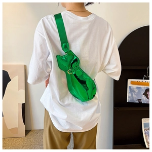 Close-up of bright green glossy cat-shaped crossbody bag with reflective mirror finish
