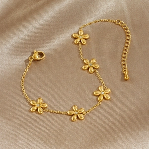 Gold-plated stainless steel flower link bracelet with sparkling cubic zirconia on champagne satin