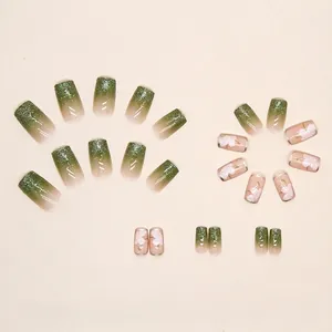 Faux ongles dégradés verts pailletés avec fleurs de camélia blanches et forme carrée-ovale