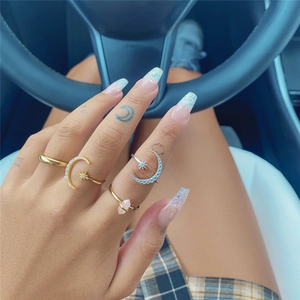 Detailed shot of celestial moon and star rings with pink crystal on a hand