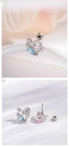 Detail of heart-shaped ear studs with drop-cut blue and pink zircons on fabric