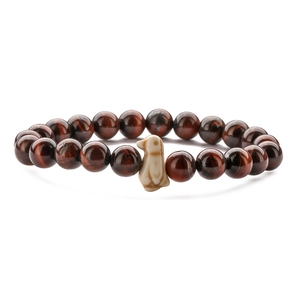 Detailed view of penguin charm on stretch bracelet with tiger eye and agate stone beads