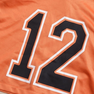 Gros plan sur tissu mesh orange respirant avec impression du numéro 12 noir bordé de blanc