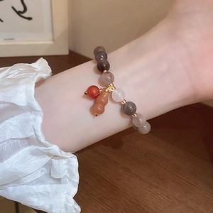 Detail of beaded bodhi seed bracelet with gourd charm on wrist, natural stone jewelry