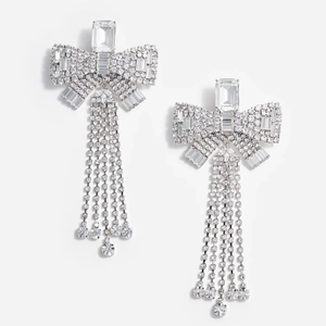 Close-up of sparkling rhinestone bow earrings with elegant silver long fringe tassels