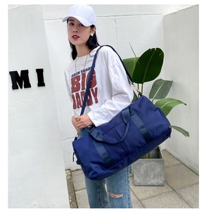 Blue high-capacity travel bag with wet-dry separation shown in an outdoor setting