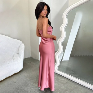 Detail view of pink satin tube dress showing the sleek backless cut and draped texture