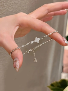Detailed macro shot of a star charm bracelet with sparkling zircons and adjustable chain