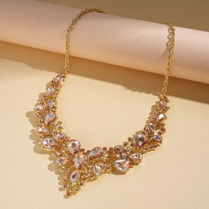 Detailed close-up of champagne teardrop gemstones and intricate gold-plated floral crystal necklace