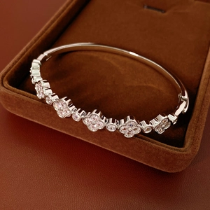 Detailed view of silver flower bracelet with pink zircon inlays in a brown velvet box