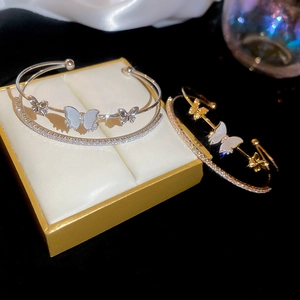 Macro shot of butterfly bangle with cubic zirconia and white shell inlay on black velvet