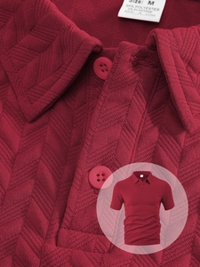 Détail d'un polo homme rouge foncé montrant la texture jacquard et l'étiquette de tissu