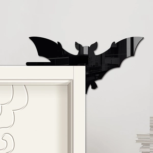 Detail of a black acrylic bat decal decorating a white door frame corner for Halloween