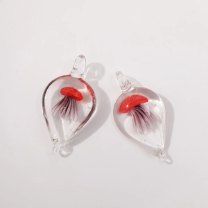 Macro detail of drop-shaped glass pendant featuring an intricate red jellyfish landscape