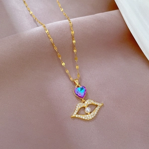 Gold lip pendant necklace with purple heart gemstone and pearl on khaki fabric