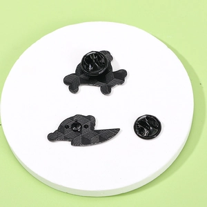 Rear view of two green frog enamel pins with black rubber clutches on white pedestal