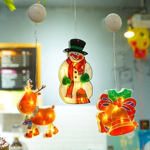 Close-up of reindeer, snowman and bell suction cup LED window lights in warm white