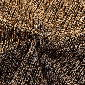 Vue macro de la texture du tricot en Lurex or et noir avec des plis et reflets brillants