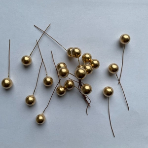 Detail of golden foam berries on wire stems for festive Christmas DIY crafts