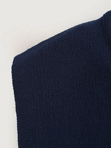 Detailed close-up of navy blue knit vest showing neckline texture and premium stitching