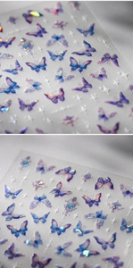 Macro shot of 3D laser butterfly nail stickers with holographic purple and blue glitter finish