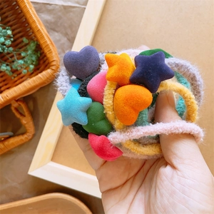 Elastici per capelli bambini con cuori e stelle in peluche colorati tenuti in mano